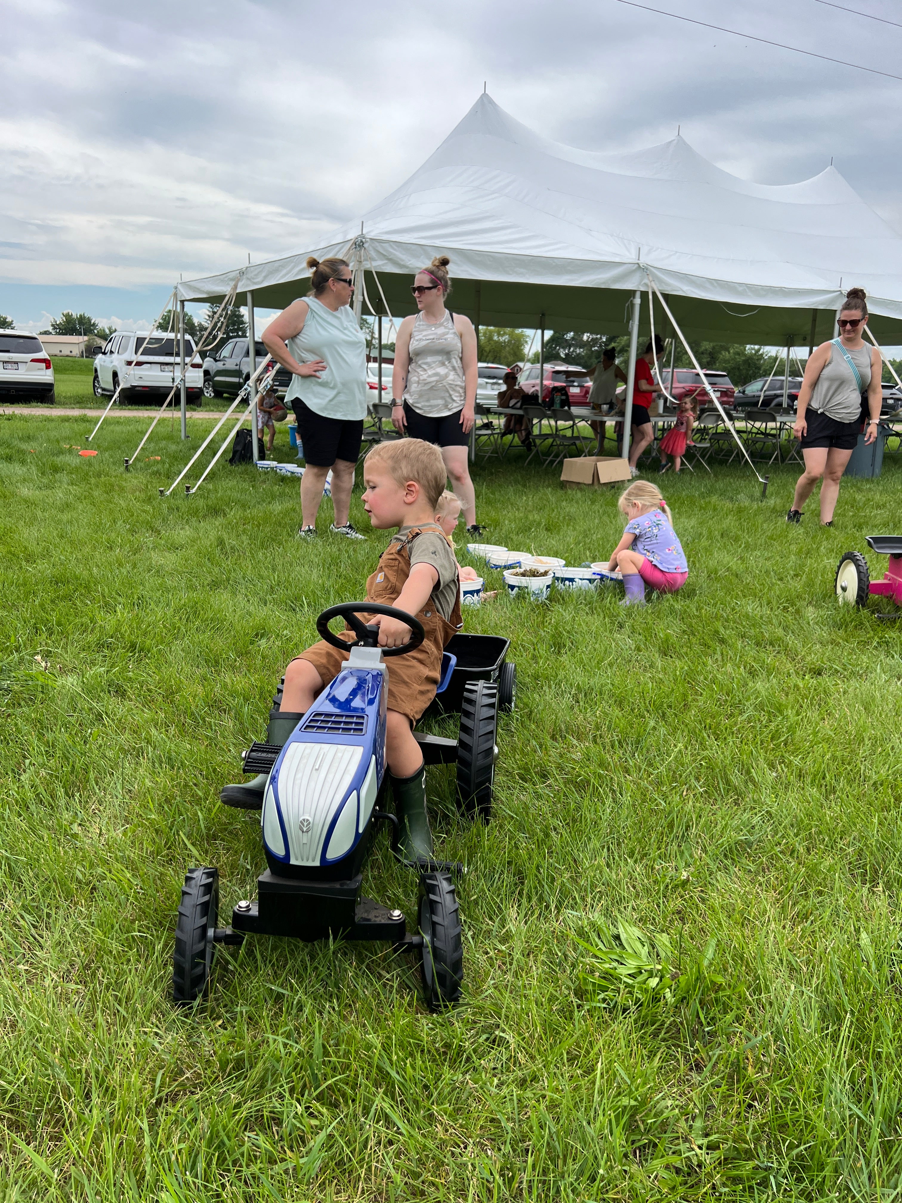 Young children enjoying Little Farmers Day on the Farm at Prairie Raised Beef—feeding baby calves, exploring sensory bins, and participating in farm-themed crafts.